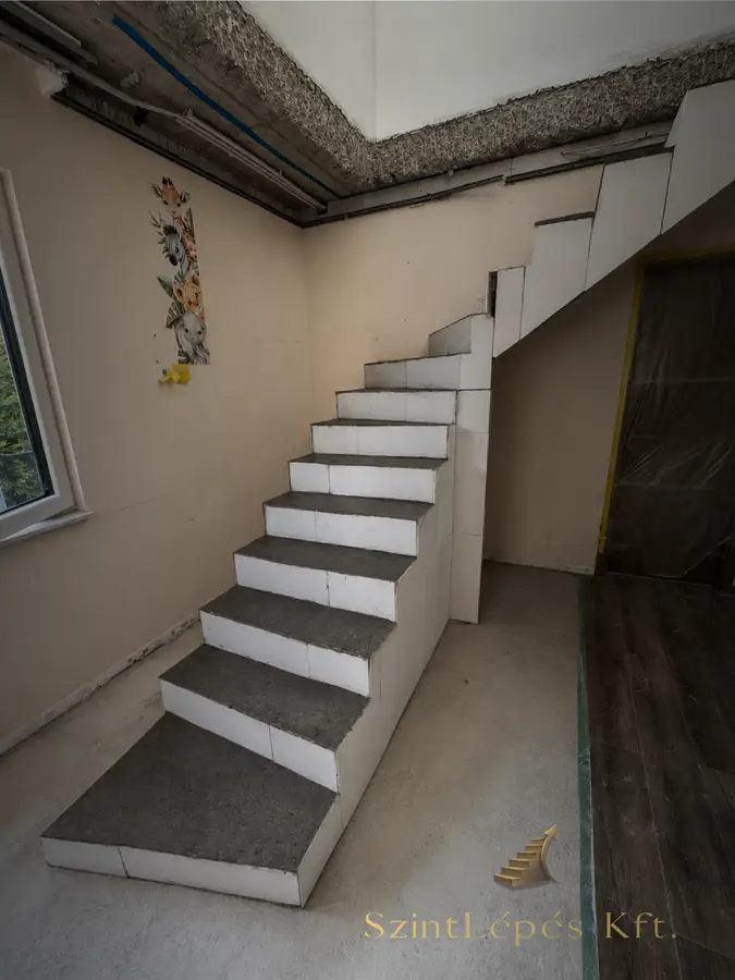 Elkészült L alakú lépcső üveg korláttal